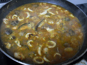 Cocinando el arroz de pescado y marisco con el fumet.