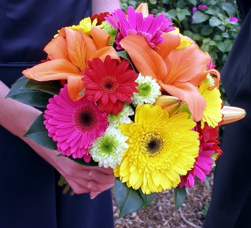 Yellow hot pink and fuchsia gerbera daisies mixed with orange lilies 