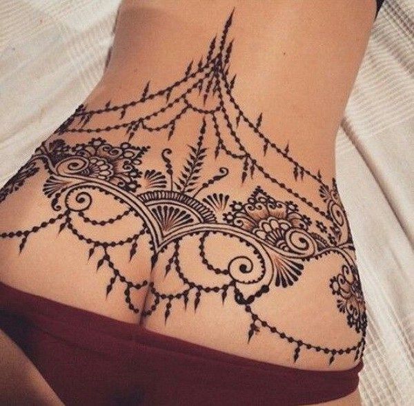 Foto de tatuaje tipo arabesco en el coxis de la mujer