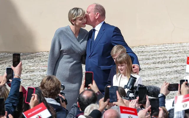 Princess Charlene wore a grey solid v-neck knitted dress by Akris. Princess Gabriella wore a white coat by Burberry