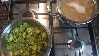 pentole con zucchine saltate e pentola con pasta che cuoce nell'acqua bollente