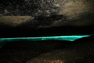 Gruta de piedra y al fondo la magia de los colores sucediendo en el agua