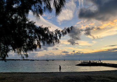 man walking on tropic beach at sunrise