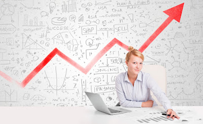 A woman sits in front of a white board with an arrow going up from left to right