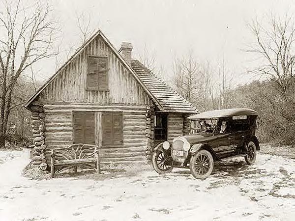 Log cabin, new Oldsmobile and 2 ladies. 1920