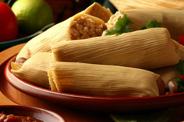 Apetitosos tamales mexicanos, platillo tradicional. Envueltos en hojas de maíz y rellenos de sabores auténticos. Un festín culinario