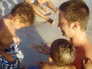 Jim shows the kids a starfish he found in the shallows (florida beach )