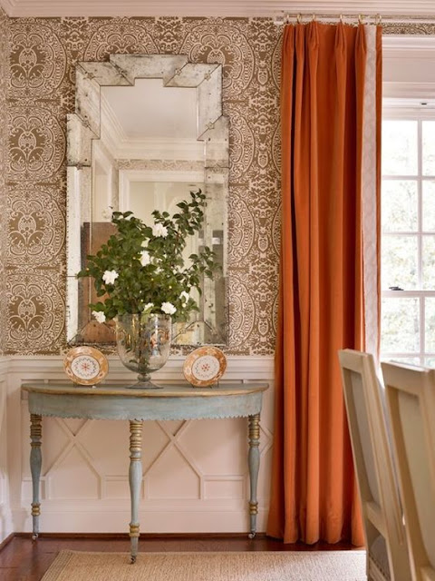 Pumpkin curtains and elegant blue demilune table in beautiful room