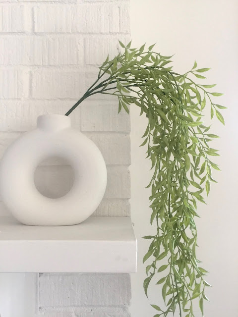 white textured modern donut vase with faux greenery vine