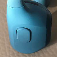 Close-up of multifunction button on Shokz OpenRun Pro headphones