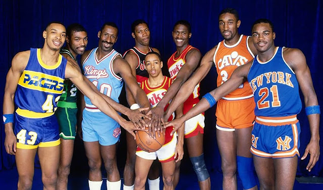 Spud Webb standing in the middle of tall NBA players