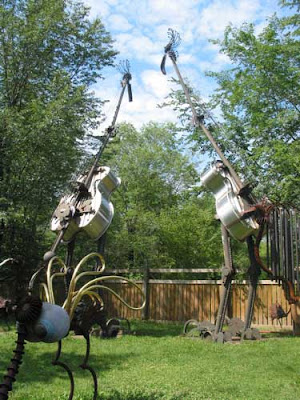 Two gian birds whose bodies look like shiny chrome cellos