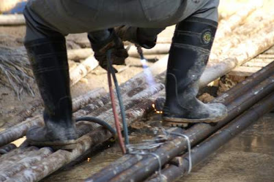 Image of a Hong Kong construction worker preparing a site for drilling out foundation piles.