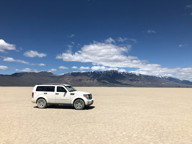 white SUV in a desert with mountains in the background