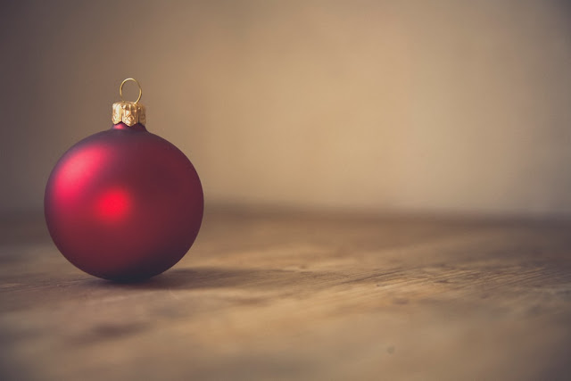 Single red bauble on a wooden table