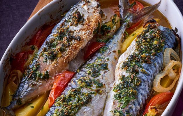 varias caballas enteras cocinadas al horno con patatas y tomate