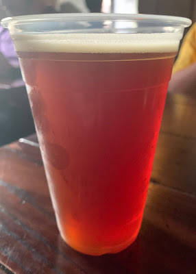 A pint of Dragon Scale red ale in a plastic cup.