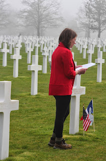 Student reading at the grave of an American soldier in Normandy, France at the Omaha Beach American cemetery