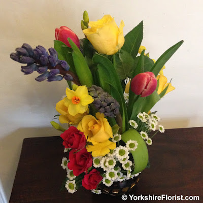  Spring flowers arranged in a glass mirrored pot