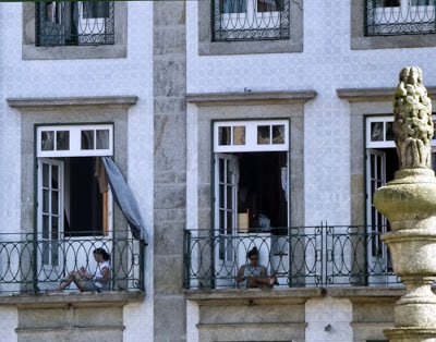 duas senhoras sentadas nas varadas de edificio do Porto