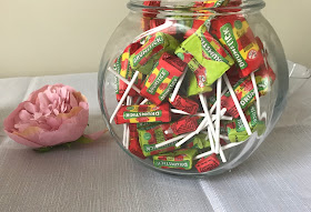 drumstick lollies in a glass jar with a pink flower 