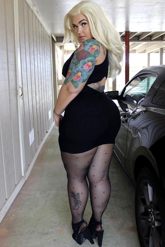 Beautiful curvy lady dressed in a LBD with black polka dot tights and black sandals