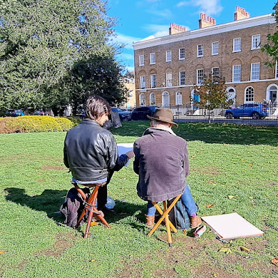 Photo of two urban sketchers in Tredegar Square sketching the view looking north towards Tredegar Terrace.