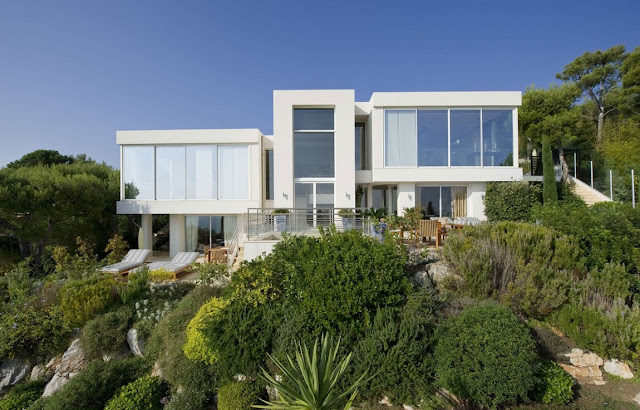 Modern white two story villa built among green vegetation