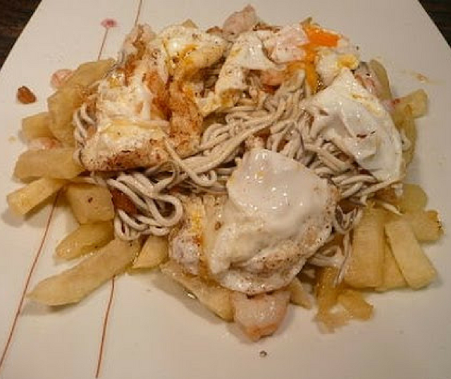 Huevos rotos con gulas y gambas