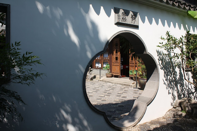 A peek inside the window invites you to step into tranquility at the Lan Su Chinese Garden in Portland, Oregon.