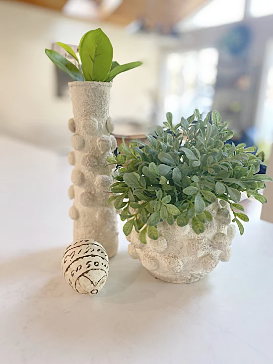 antiqued looking white textured vases with greenery