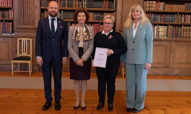 Queen Silvia wore a grey tweed jacket by Chanel. Beige ruffled silk blouse. Versace atelier silk scarf. Vincent Wang and Iris Forssberg