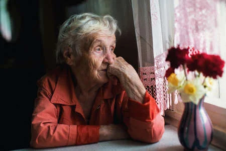 101895324 anciana mira con tristeza por la ventana