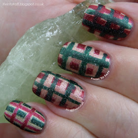 Tartan plaid nail art in Christmas colors red, green, and gold.