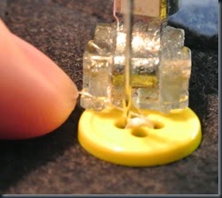 See the thread securing the button.