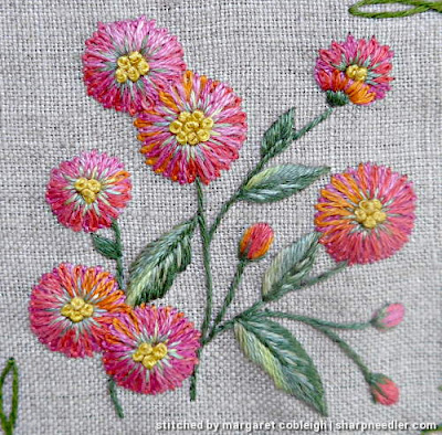 Details of floral motif with pink and orange flowers. Flowers are stitched with 2 layers of pink/orange House of Embroidery variegated threads.