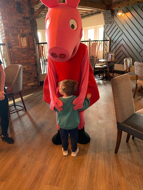 Little boy hugging Peppa Pig character