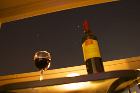 wine bottle and wine glass in front of stars background