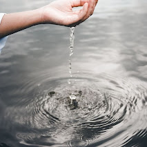 A human hand collects water from a reservoir