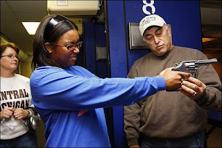 Cicely Howze of Livonia practices her hand position and the pressure needed to pull the revolver's trigger as instructor Cpl. Jim Combs of the Wayne County Sheriff's Office talks her through it during a women-only permit class at a shooting range in Westland. (Bryan Mitchell / Special to The Detroit News)