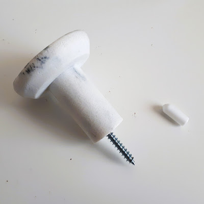 Marble-look wall hook with a large screw sticking out of the end.