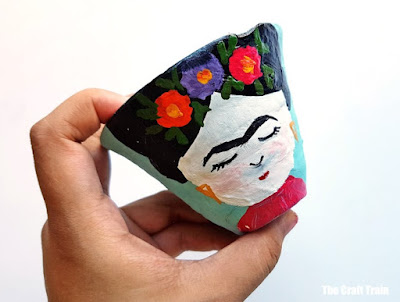 a picture of Frida Kahlo has been painted on this terracotta flower pot