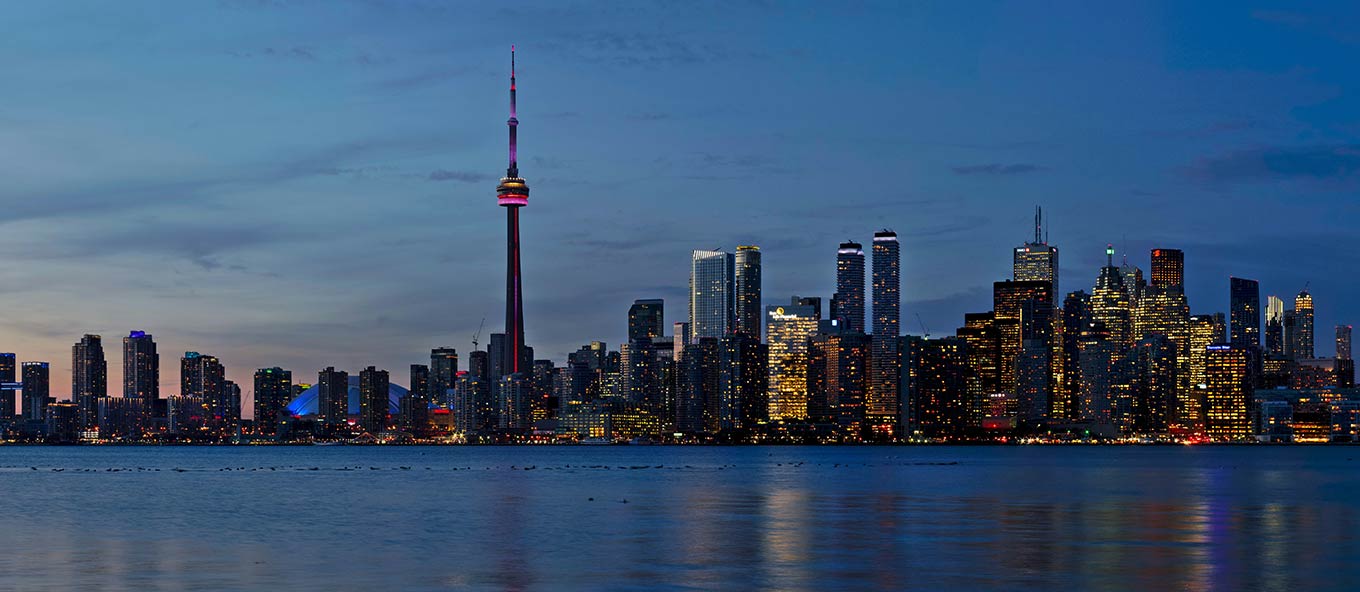 Wide photo of the entire Toronto skyline at night.