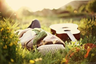 chica con la guitarra en el pasto al sol