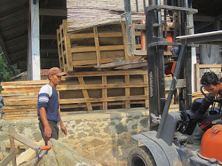 bongkar muat pesanan bahan baku fosil kayu