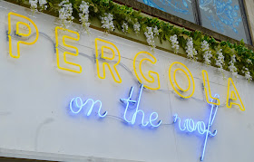 Pergola on the Roof neon sign and flowers