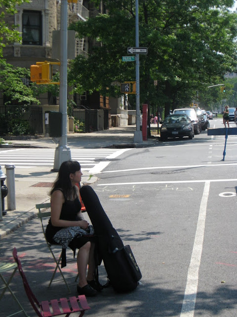 woman sitting alone on street with instrument