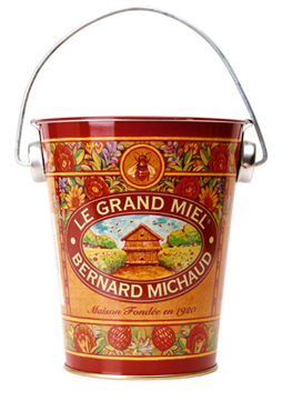 colorful pail storing honey, labeled Le Grand Miel