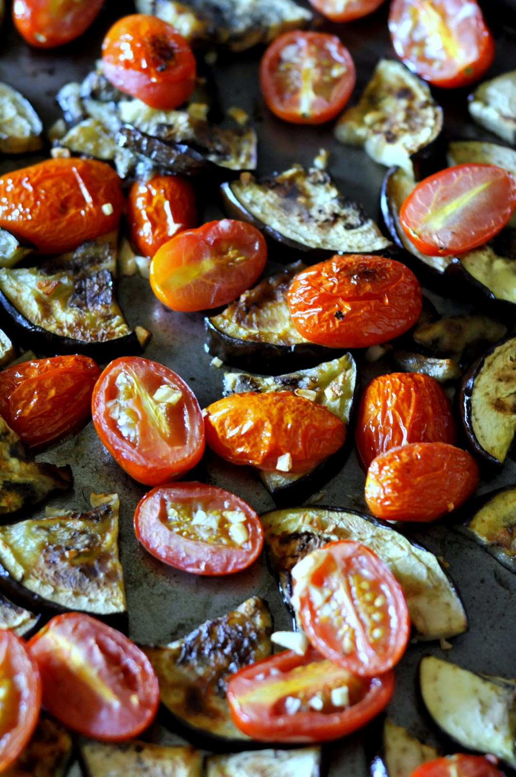 Roast eggplant with grape tomatoes and garlic for a tasty topping for your Friday night pizza.