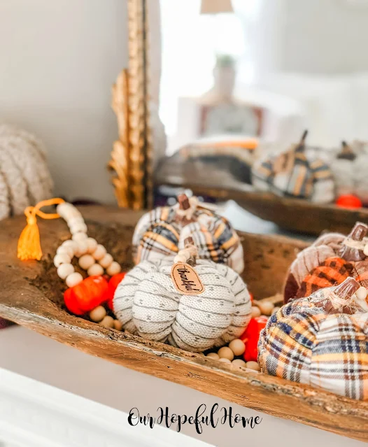 wooden dough bowl filled with flannel pumpkins and wood bead garland